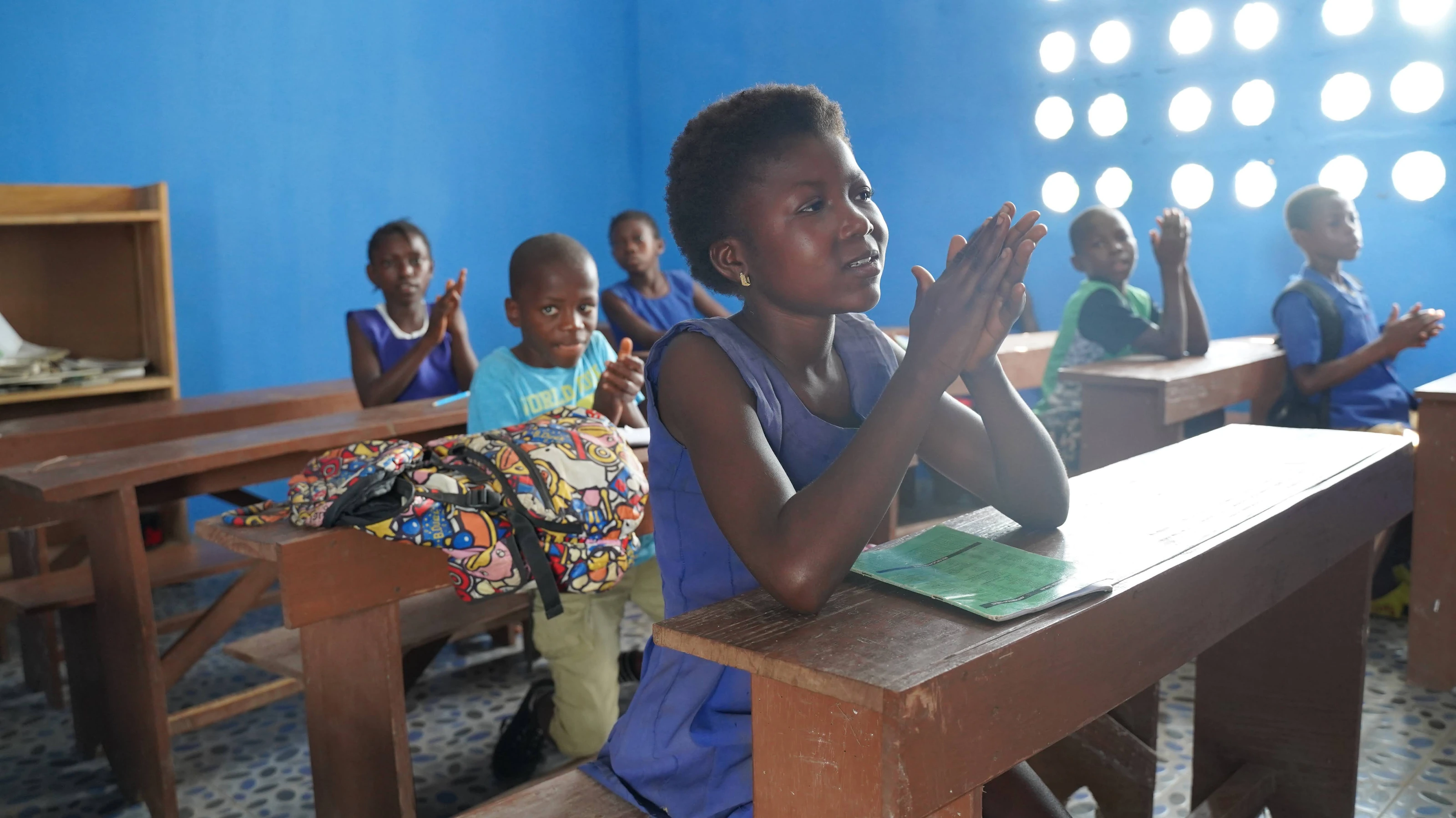 A student clapping during class in Sierra Leone