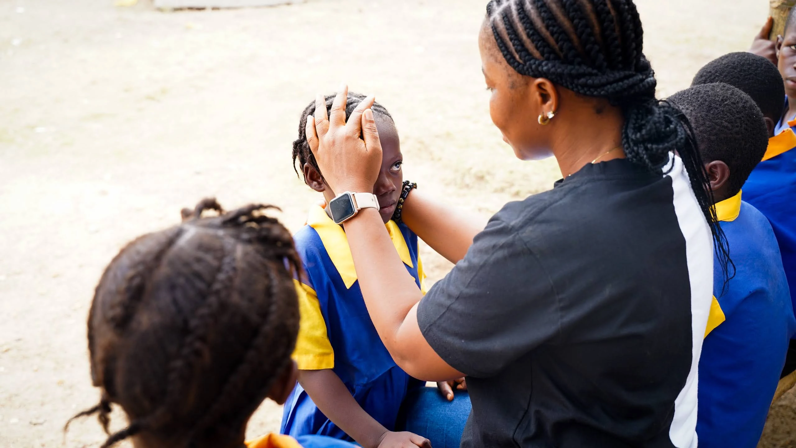 Teacher comforting a student, Sierra Leone